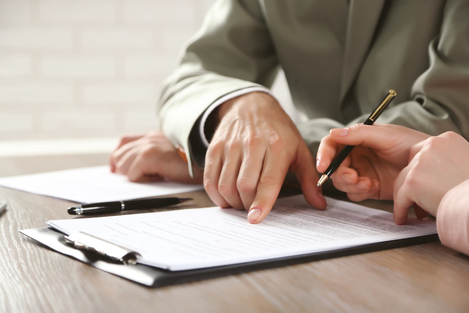 Hands reviewing compliance documents at a desk, illustrating the manufacturer duty to draw up an EU Declaration of Conformity
