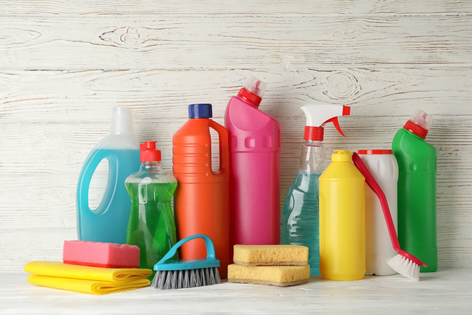A group of household cleaning product bottles and detergent containers