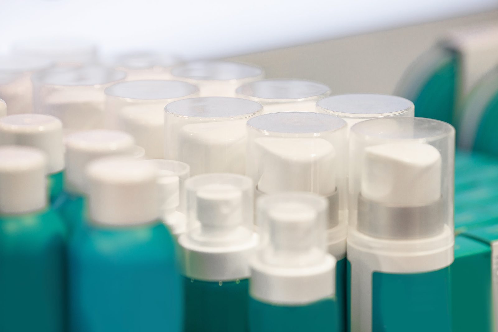 A row of near identical blank cosmetic bottles on a retail shelf