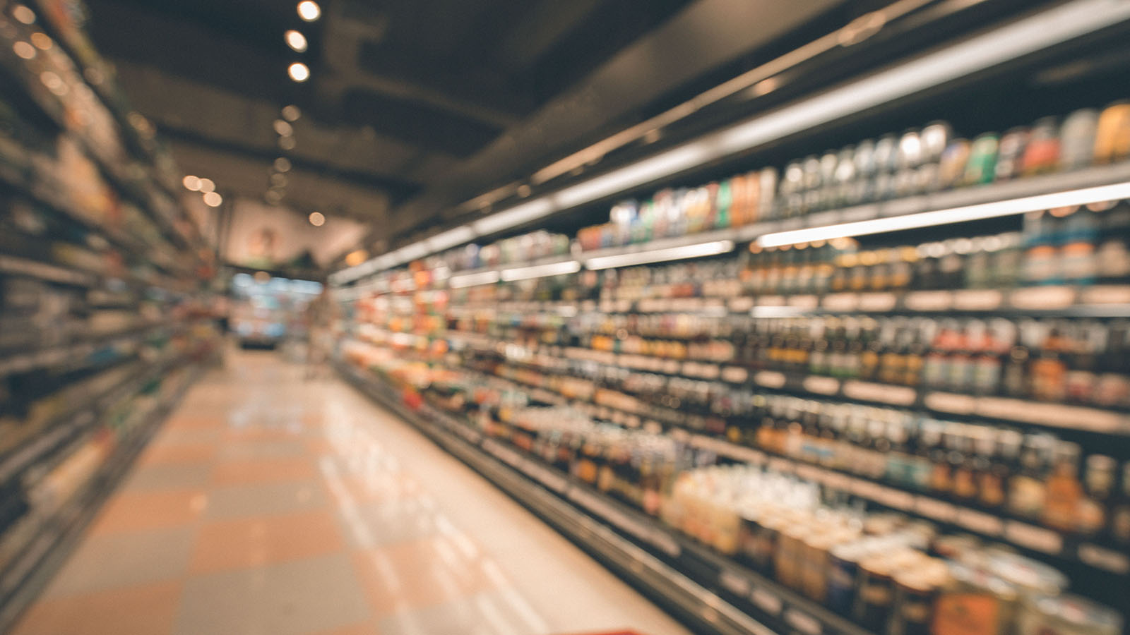 Softly focused retail aisle with shelving stocked full of packaged consumer products