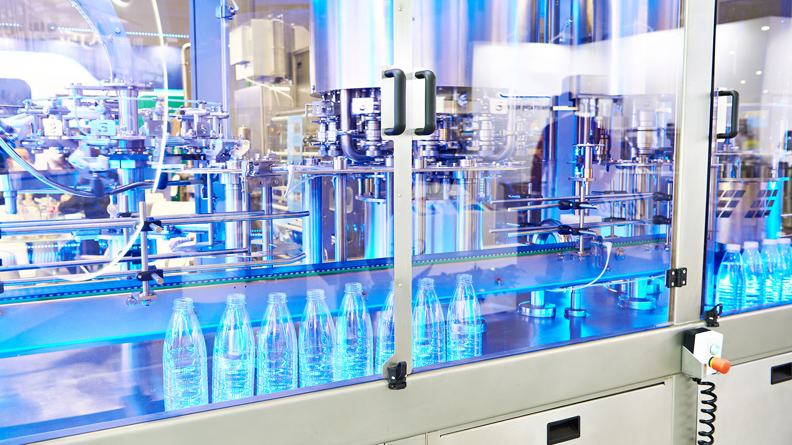 Clear plastic bottles moving along a packaging conveyor at a beverage plant